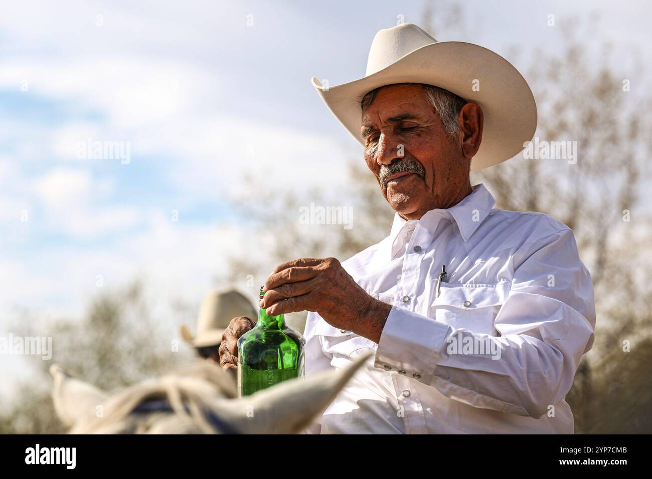 Cowboy mit Bacanora aus Agave destilliert beim Cristo Rey Ausritt zur Stadt La Puerta del Sol in URES Sonora Mexiko... (Foto: Luis Gutierrez / NorthPhoto) Vaquero con Bacanora destilado originario de Agve en la Cabalgata al Cristo Rey al pueblo La Puerta del Sol en URES Sonora Mexico... (Foto für Luis Gutierrez / NorthPhoto) Stockfoto