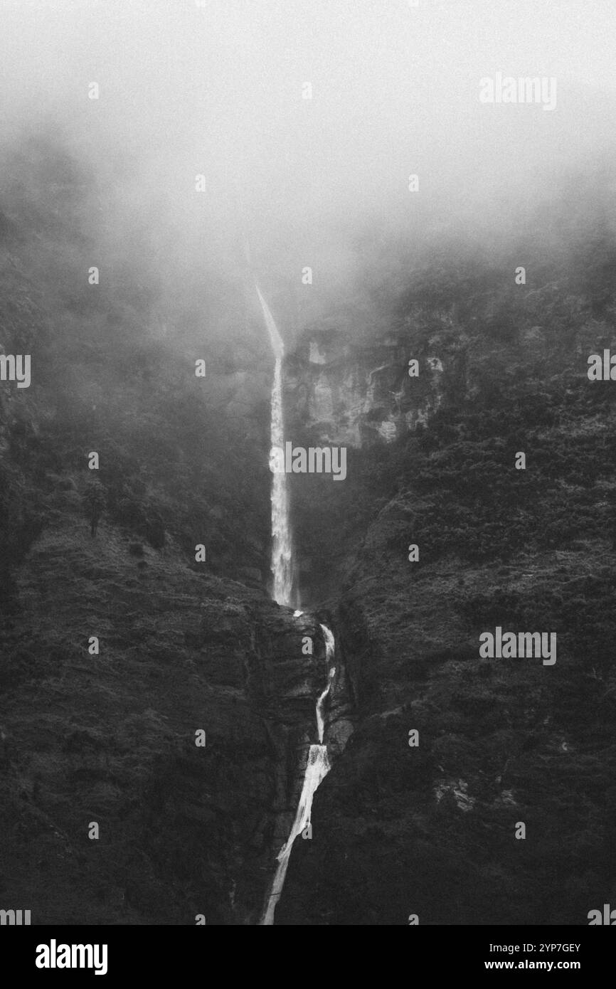 Ein schmaler Wasserfall inmitten steiler, nebeliger Klippen, Wanaka, Neuseeland, Ozeanien Stockfoto