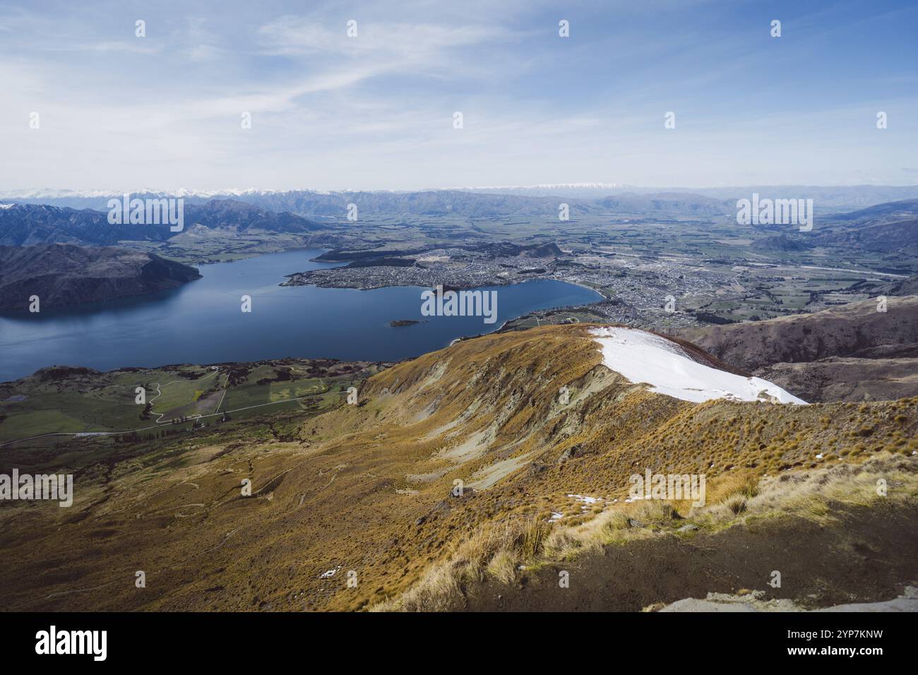 Landschaft mit einem weiten Blick auf einen See, ein Tal und eine ferne Stadt, Roys Peak, Wanaka, Neuseeland, Ozeanien Stockfoto