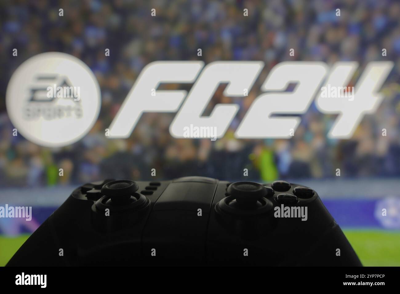 In dieser Fotoabbildung wird das EA Sports FC 24-Logo-Spiel auf einem Computerbildschirm neben einem Gamepad angezeigt Stockfoto