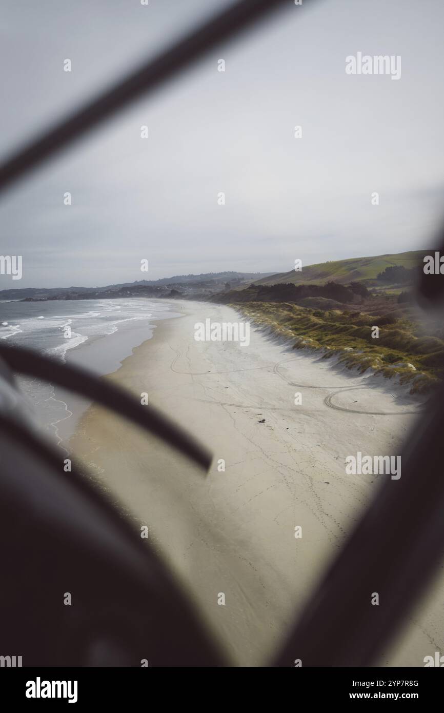 Aus der Vogelperspektive auf einen einsamen Strand mit sanften Wellen und düsterem Himmel, Dunedin, Neuseeland, Ozeanien Stockfoto