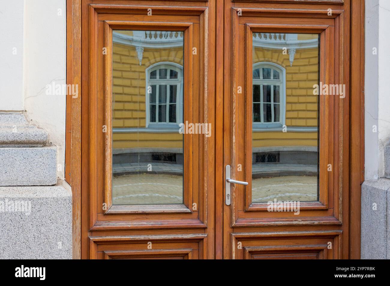 Verzerrte Realität: Reflexionen auf dem hölzernen Türrahmen Stockfoto