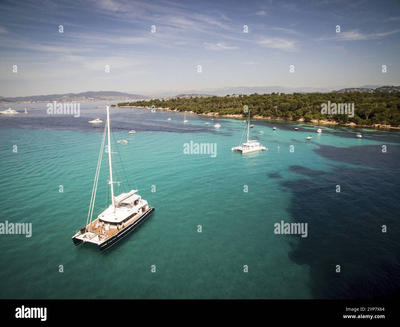 Katamaransegeln im blauen Wasser in Südfrankreich, schöner Katamaran neben der kleinen Insel während der Sommerferien Stockfoto