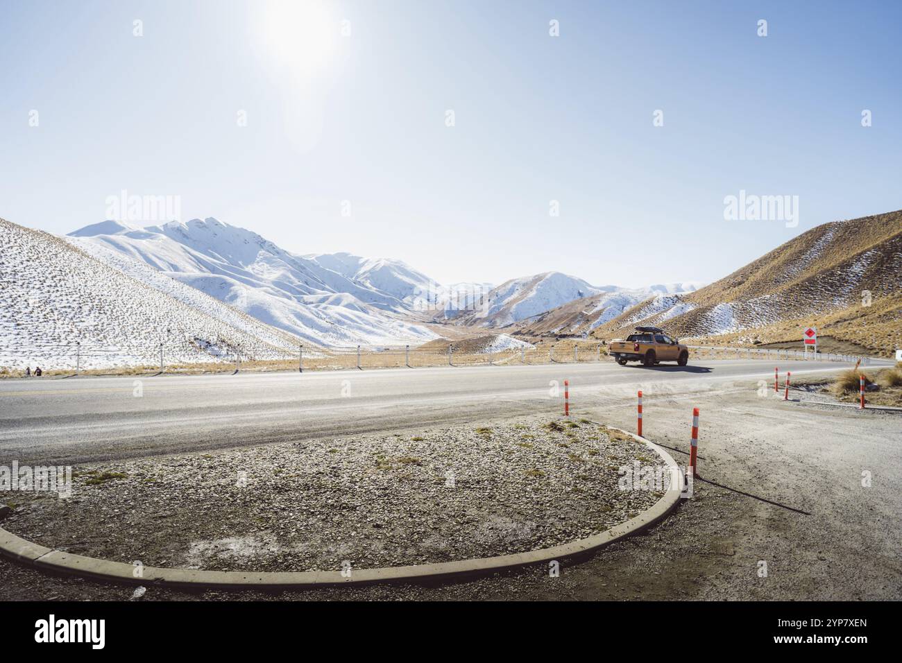 Offene Berglandschaft mit schneebedeckten Gipfeln und einem Fahrzeug auf der Straße, Lindis Pass, Neuseeland, Ozeanien Stockfoto