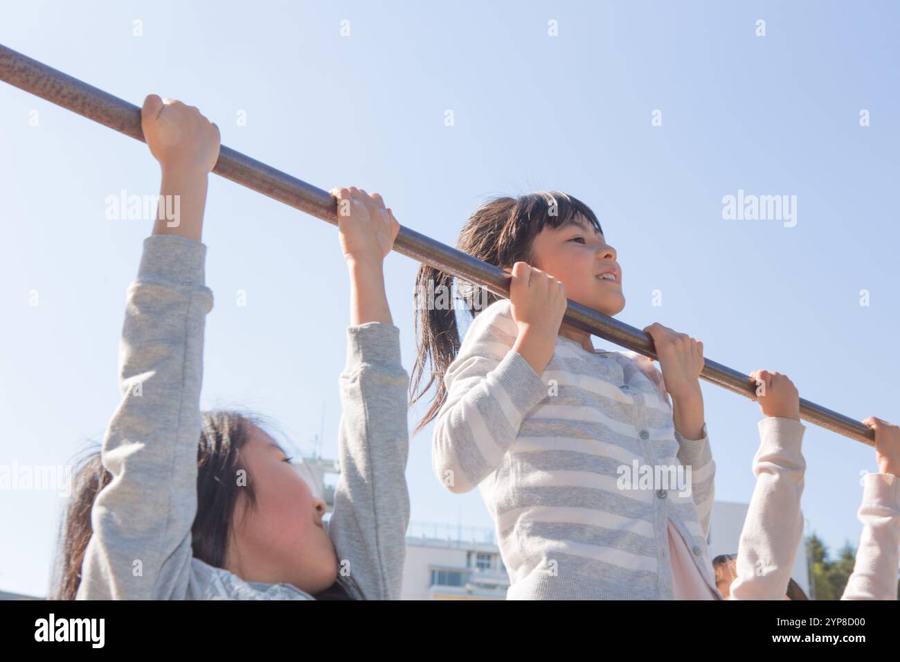 Grundschulkinder spielen auf den Eisenstangen Stockfoto