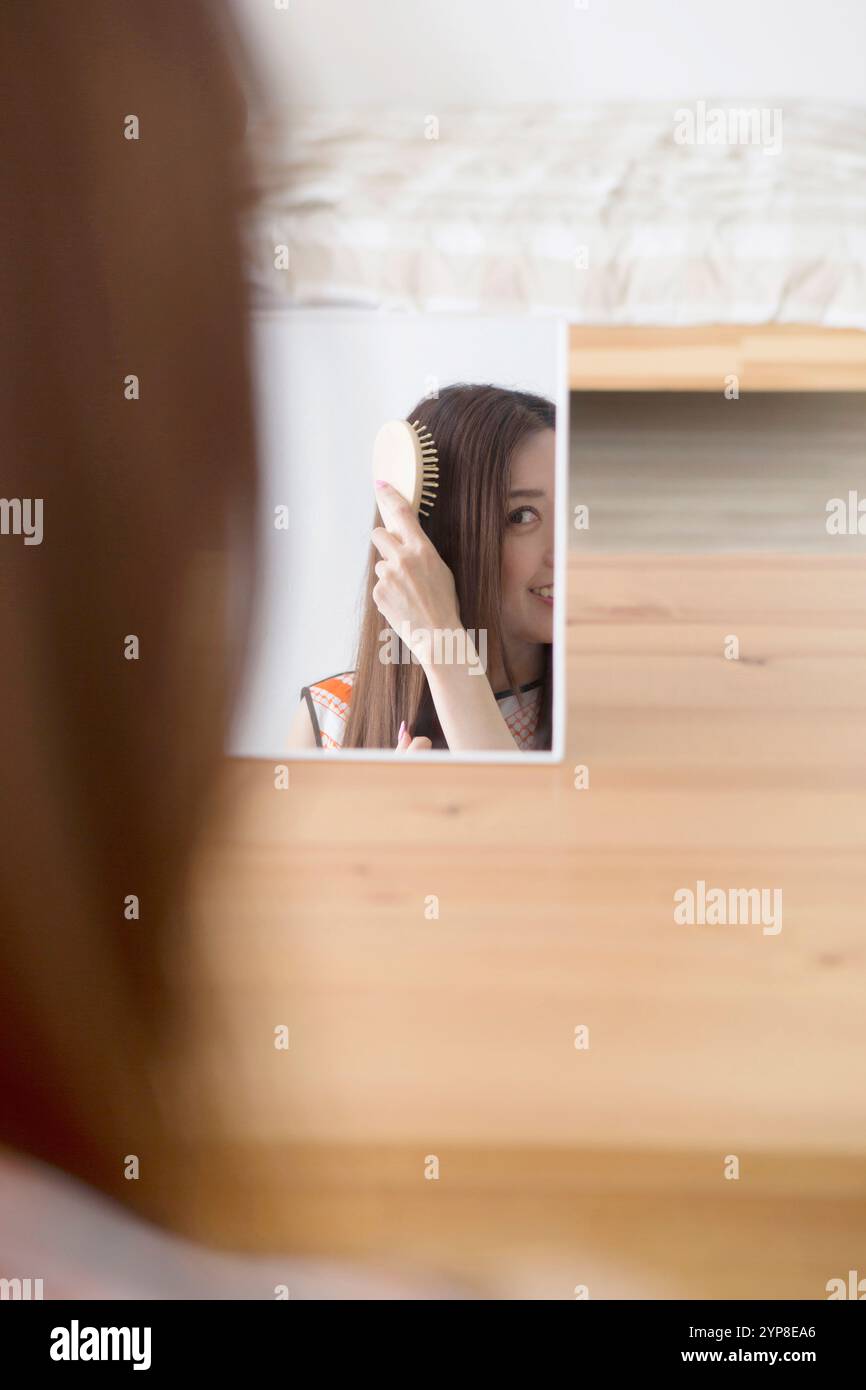 Frau putzt Haare im Zimmer Stockfoto