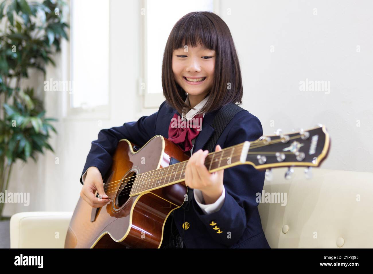 Junior Highschool Schüler spielt Gitarre Stockfoto