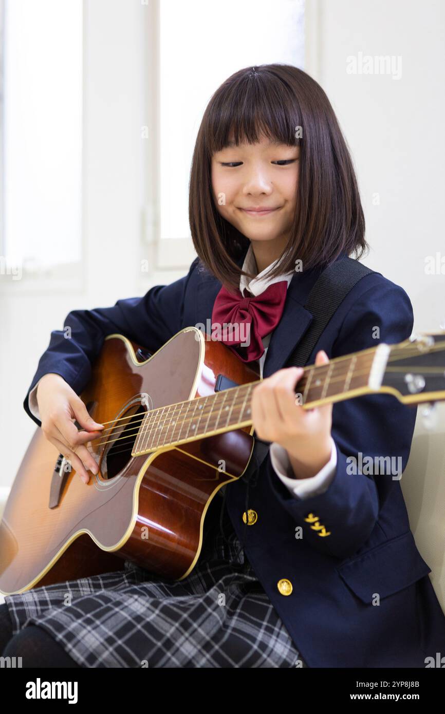 Junior Highschool Schüler spielt Gitarre Stockfoto