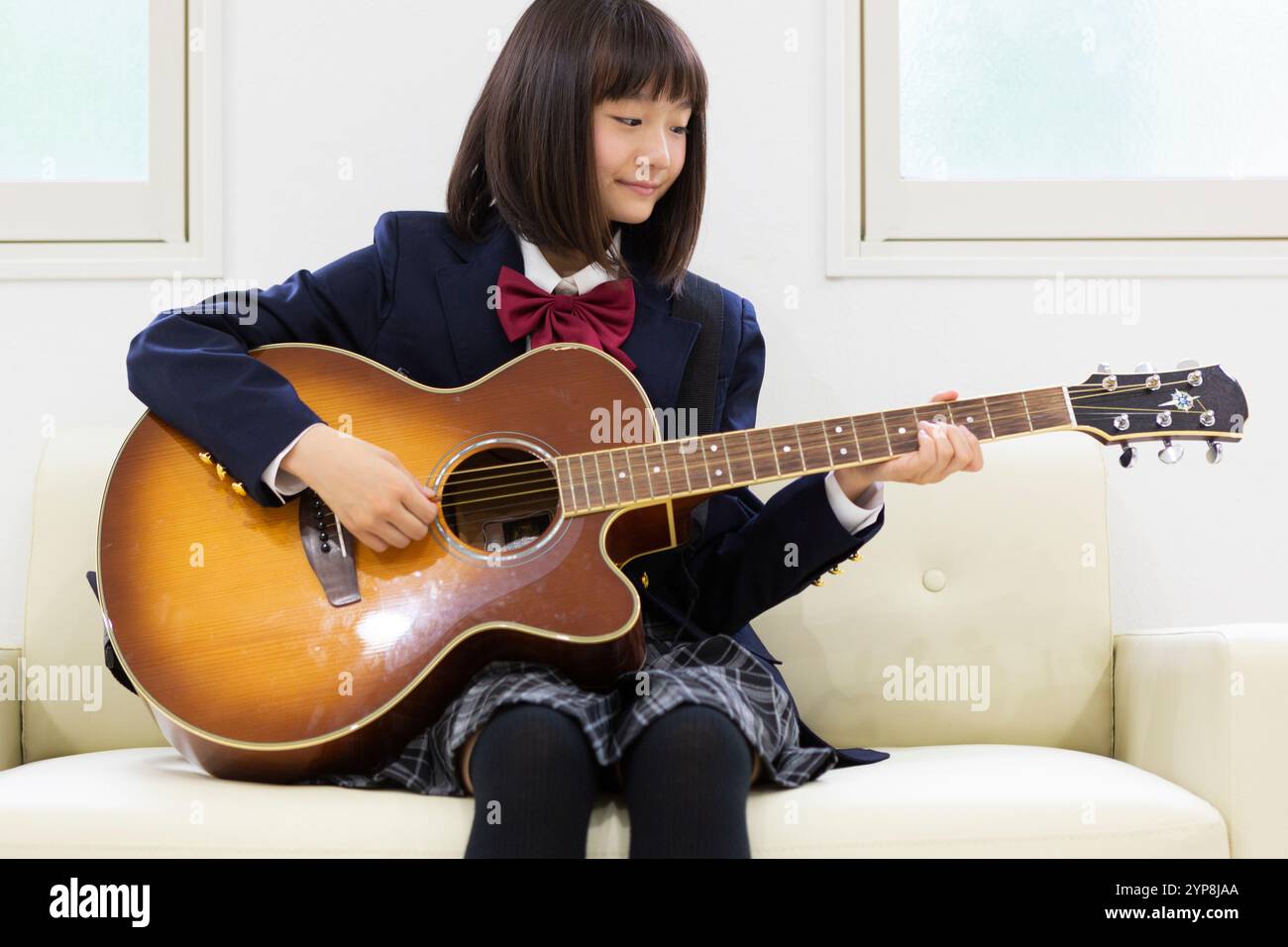 Junior Highschool Schüler spielt Gitarre Stockfoto