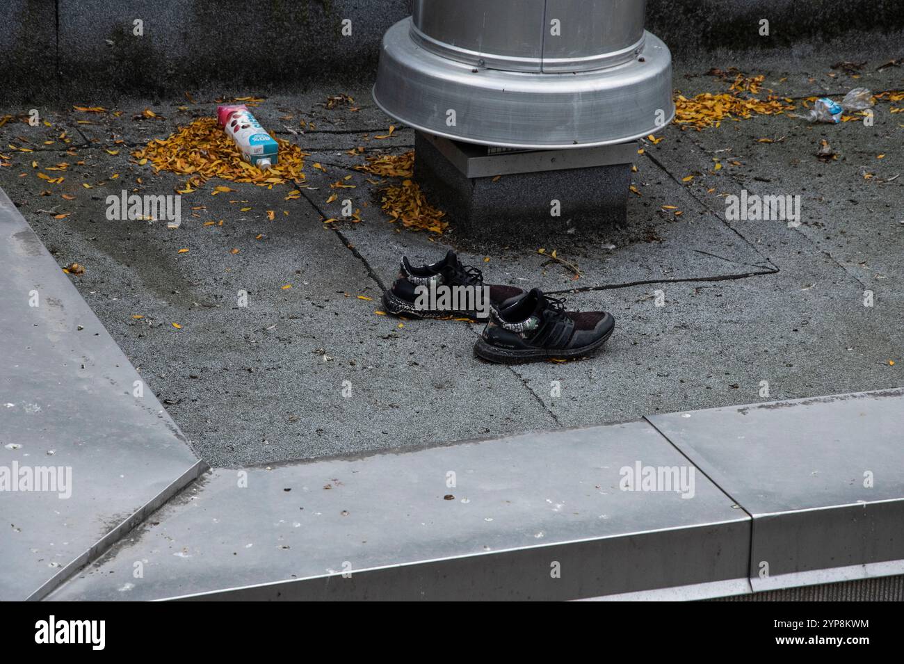 Ein Paar schwarze Schuhe und ein leerer tetra Pack-Getränkekicher auf einem Dach in Toronto, Ontario, Kanada Stockfoto
