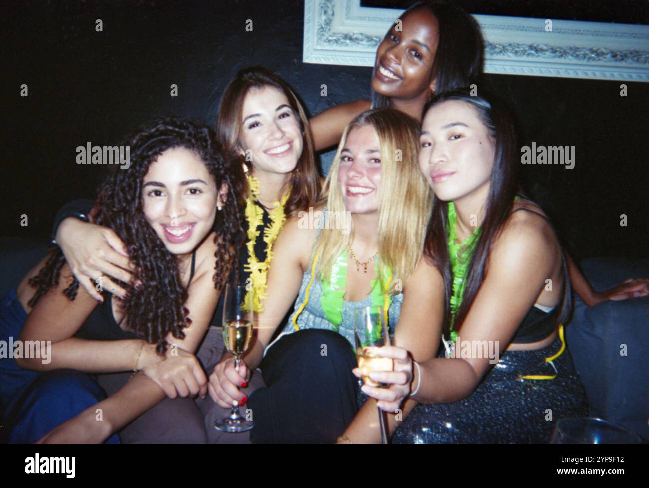 Eine Gruppe glücklicher Freunde, die eine Feier mit Champagner genießen. Das im Vintage-Stil gehaltene Bild weckt Freude und Zweisamkeit. Stockfoto