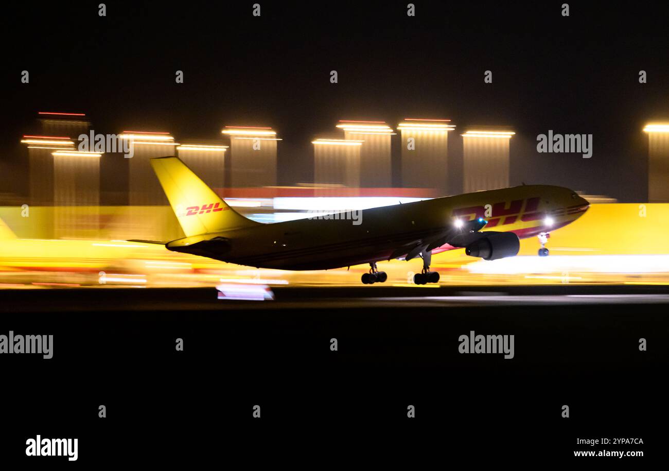 Leipzig, Deutschland. November 2024. Ein DHL-Flugzeug landet am späten Abend am DHL-Drehkreuz am Flughafen Leipzig/Halle. Mit dem Frachtzentrum der Post-Tochter DHL ist der Flughafen eines der weltweit wichtigsten Luftfrachtzentren. Quelle: Hendrik Schmidt/dpa/Alamy Live News Stockfoto
