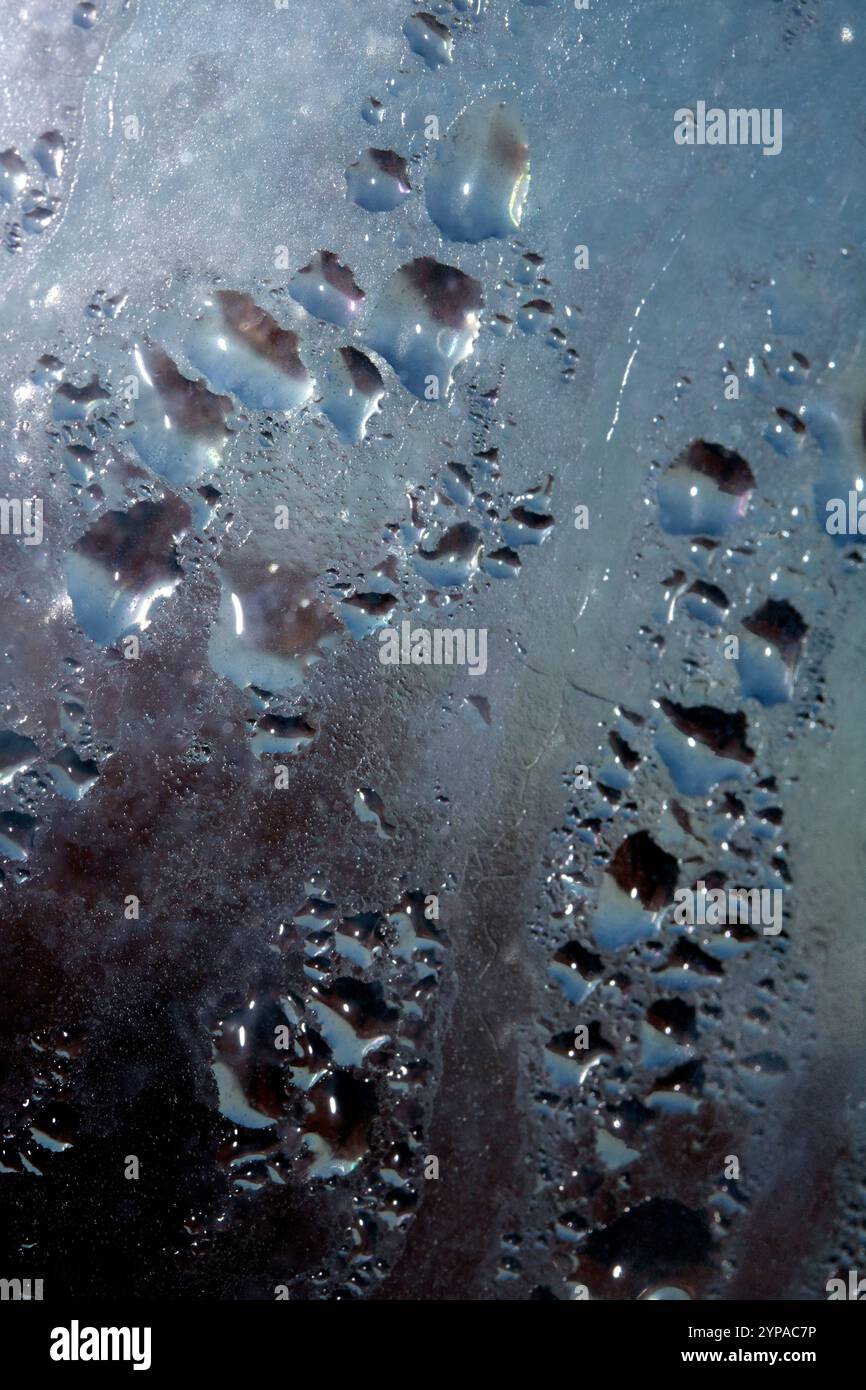 Deilcate Regentropfen Wasser auf Glas in einem blauen Glow für Hintergrund Stockfoto