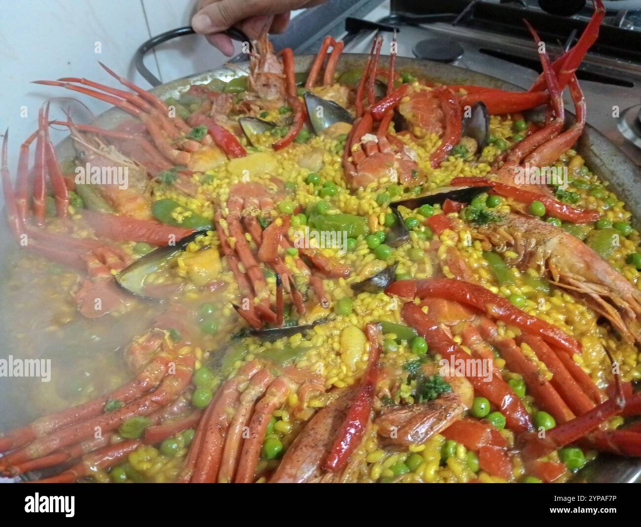 Nahaufnahme eines Tellers mit Meeresfrüchtepaella, einem traditionellen spanischen Gericht, auf einem Holztisch Stockfoto