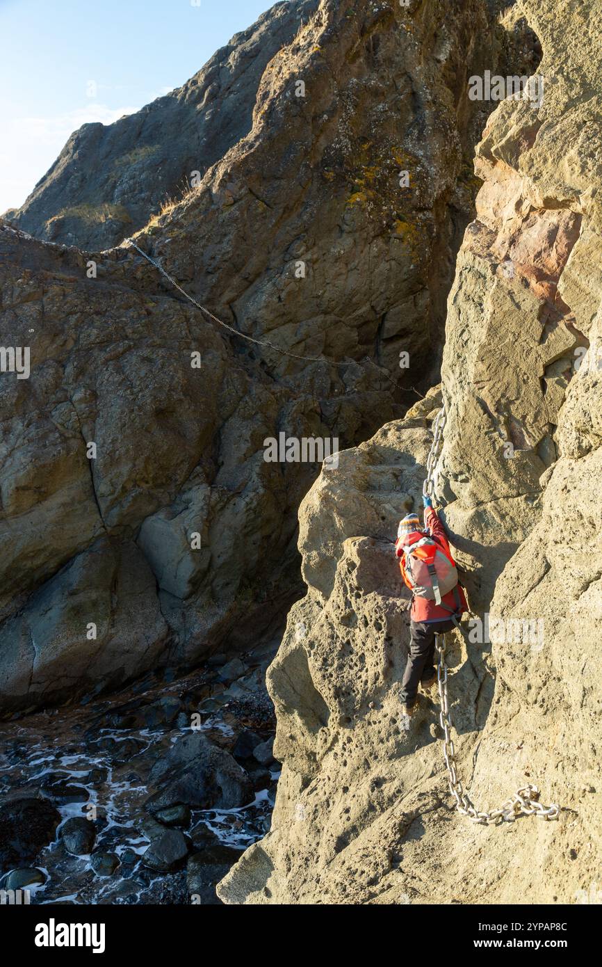 Eine Person klettert Ketten auf dem berühmten Elie Chain Walk, Elie, Fife, Schottland Stockfoto