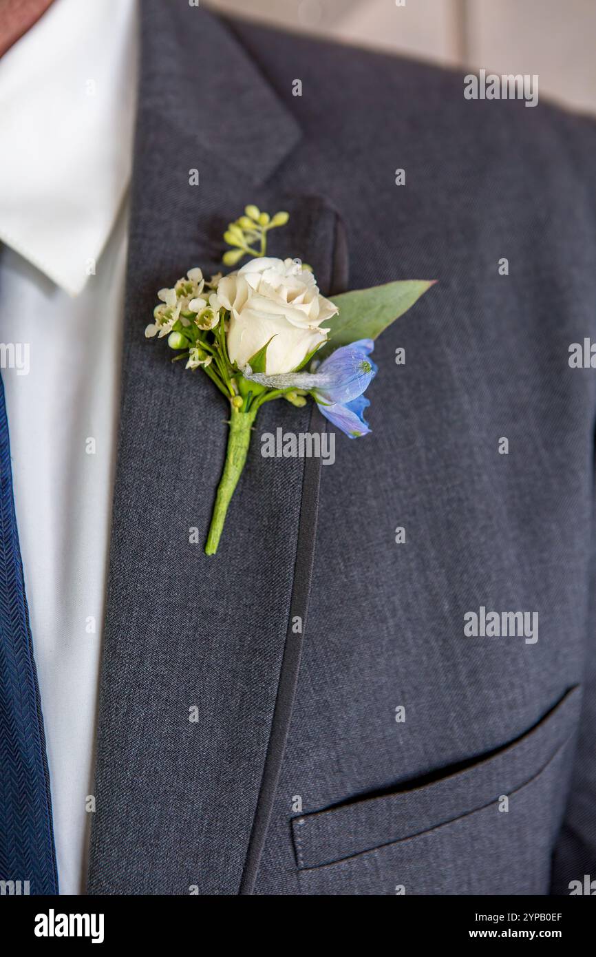 Hübscher Bräutigam in elegantem Anzug mit Blumenboutonniere am Hochzeitstag Stockfoto