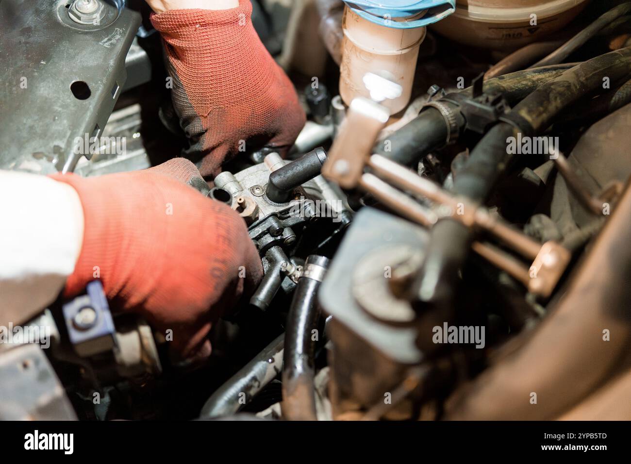 Mechaniker, der bei der Fahrzeugwartung an Motorkomponenten arbeitet Stockfoto