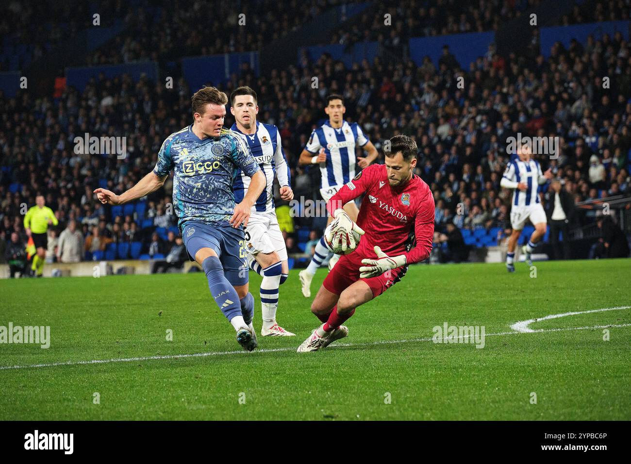 Donostia / San Sebastián, Gipuzkoa, Spanien - 28. November 2024: Álex Remiro stoppt Christian Rasmussens Angriff im Spiel Real Sociedad gegen AFC Ajax, Teil der Europa League, in der reale Arena. Quelle: Rubén Gil/Alamy Live News. Stockfoto