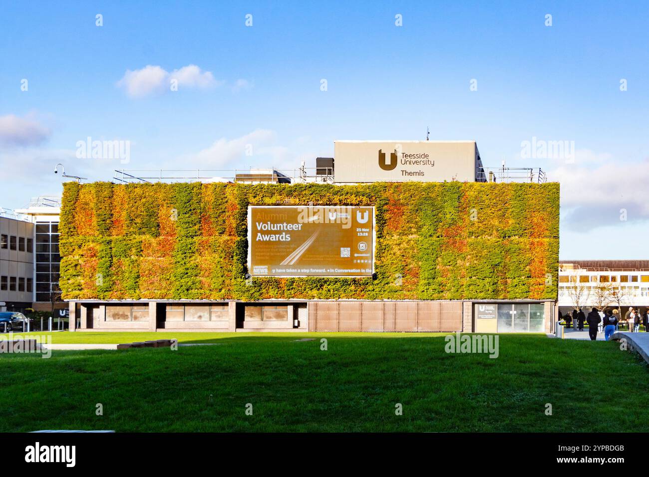 Teesside University Campus Gebäude mit vertikalem Grün und einem großen Schild mit Text über die Auszeichnungen von Freiwilligen an der Universität in einem öffentlichen Bereich Stockfoto