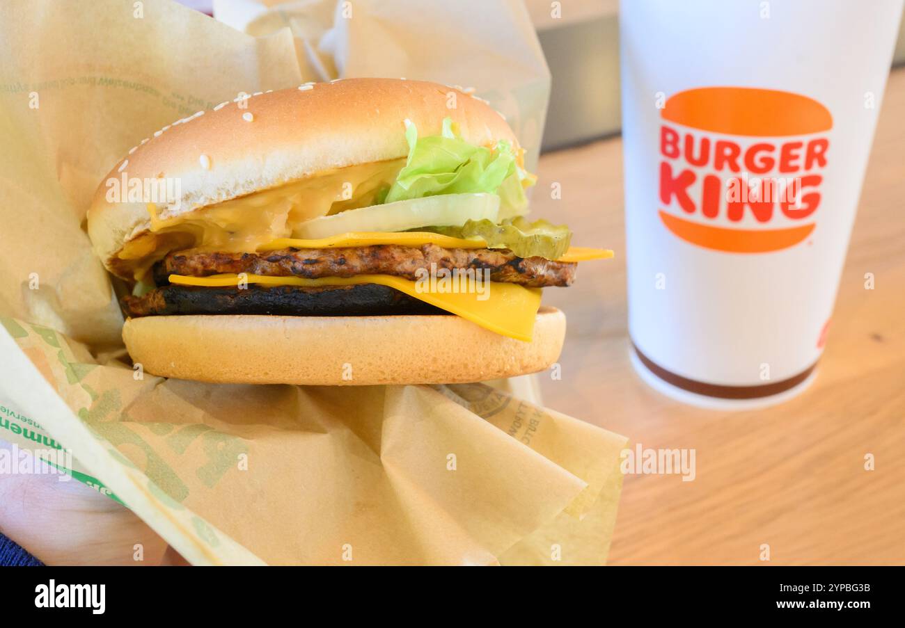 Hannover, Deutschland. November 2024. ABBILDUNG: Ein Mann hält einen pflanzenbasierten Burger Big King in einem Restaurant einer Burger King-Fast-Food-Kette. Quelle: Julian Stratenschulte/dpa/Alamy Live News Stockfoto