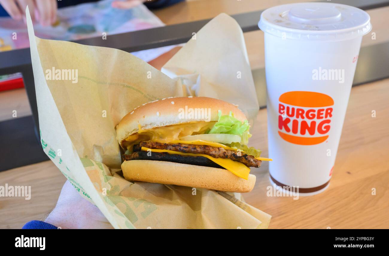 Hannover, Deutschland. November 2024. ABBILDUNG: Ein Mann hält einen pflanzenbasierten Burger Big King in einem Restaurant einer Burger King-Fast-Food-Kette. Quelle: Julian Stratenschulte/dpa/Alamy Live News Stockfoto