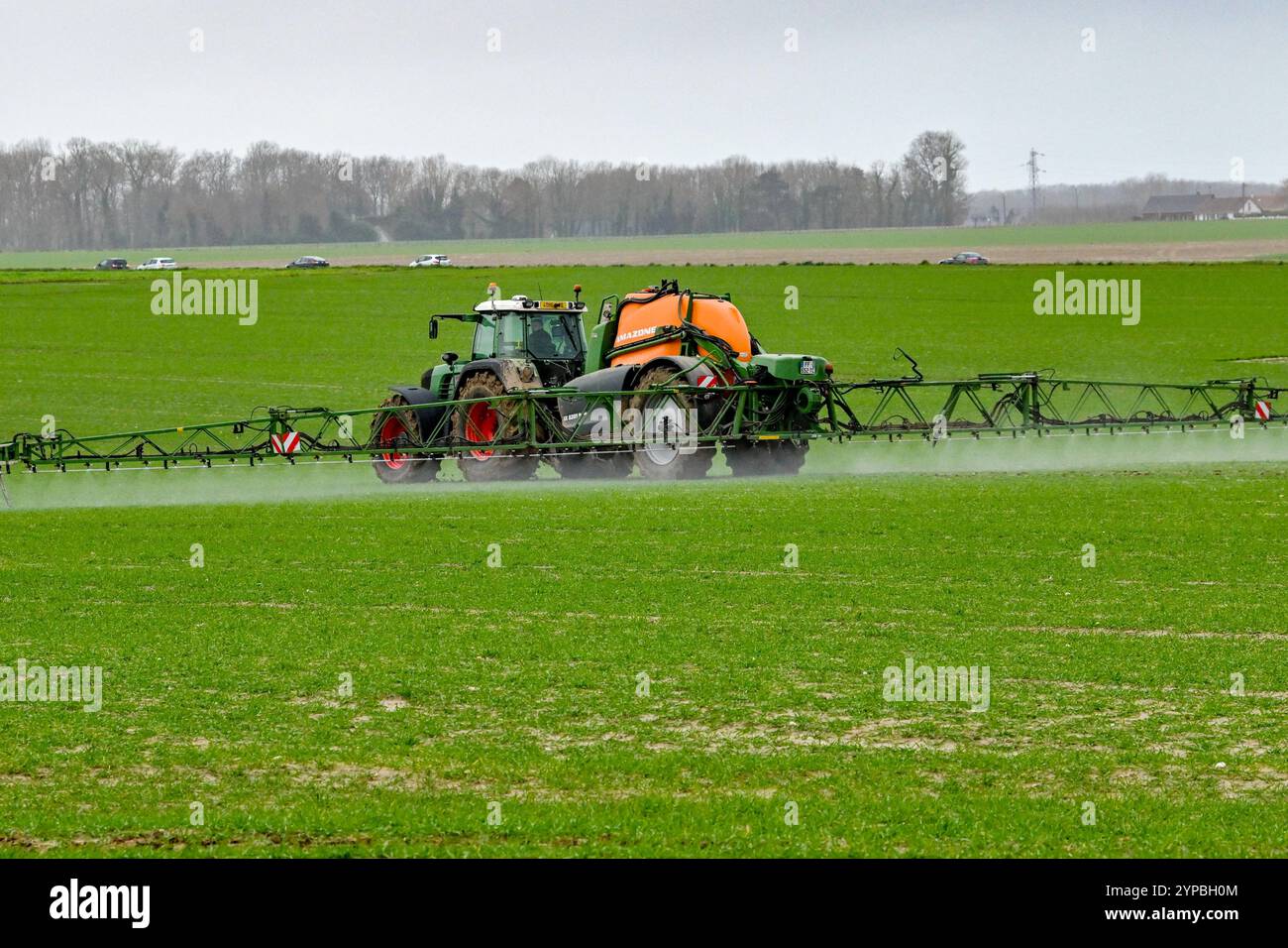 Pflanzengesundheitliche Behandlung einer landwirtschaftlichen Parzelle. Traktor mit Güllestreuer auf dem Feld. Sprühen von Pestiziden, Phytopharmazeutika und bi Stockfoto