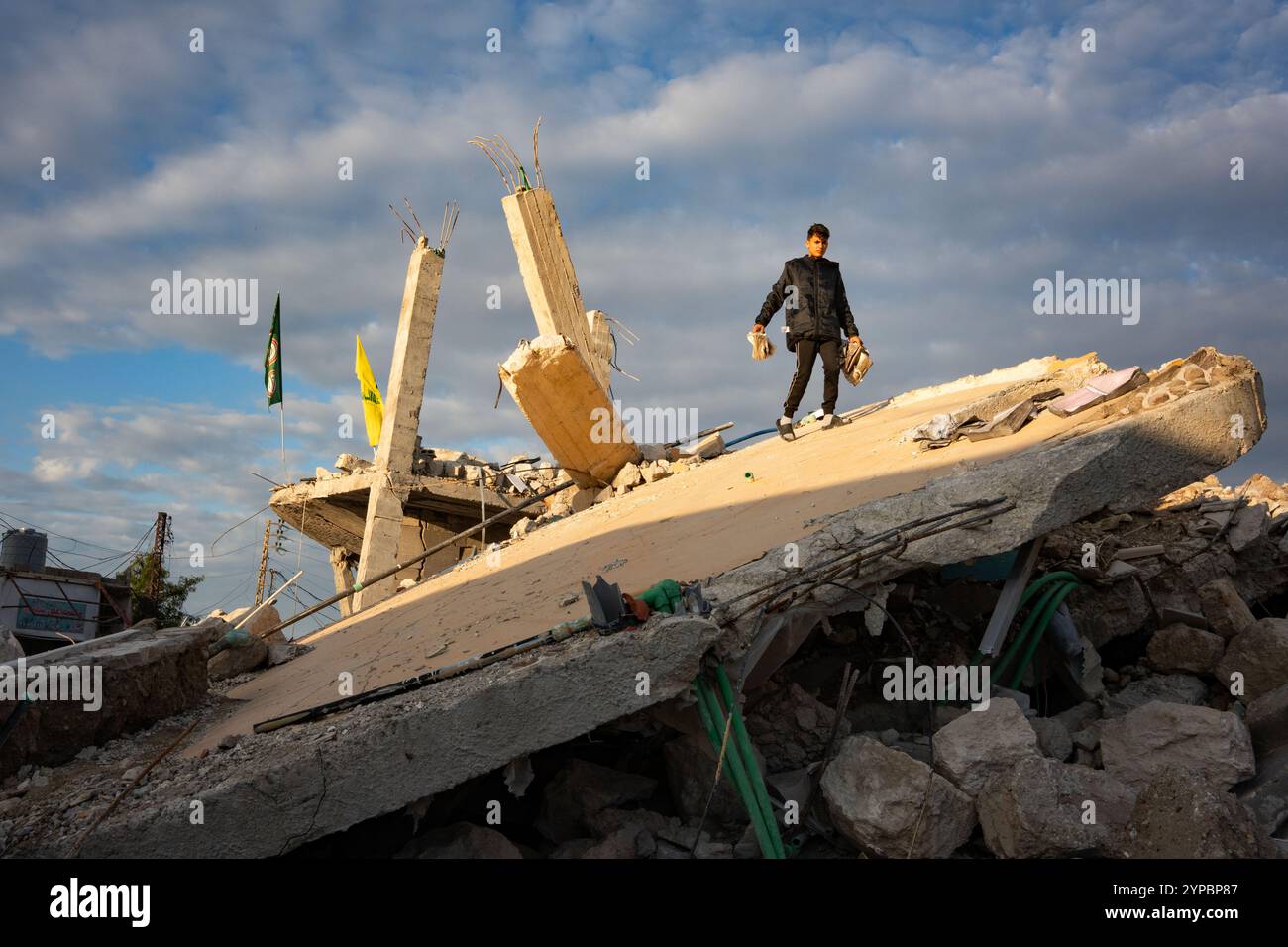 Nabatieh, Libanon. November 2024. Ein Junge geht am zweiten Tag des Waffenstillstands über ein Gebäude, das durch Beschuss in der südlibanesischen Stadt Tyr zerstört wurde. Der Krieg zwischen der Hisbollah und Israel führte dazu, dass 1,3 Millionen Menschen aufgrund von Bombenanschlägen aus ihren Häusern flohen und mindestens 4.000 Menschen starben. Nach dem Waffenstillstand am 26. November wurden die Straßen des Libanon nach Dahiye und in die südlichen Städte mit einer großen Anzahl von Wohnwagen gefüllt, die in ihre Heimat zurückkehrten. (Foto: Ximena Borrazas/SOPA Images/SIPA USA) Credit: SIPA USA/Alamy Live News Stockfoto