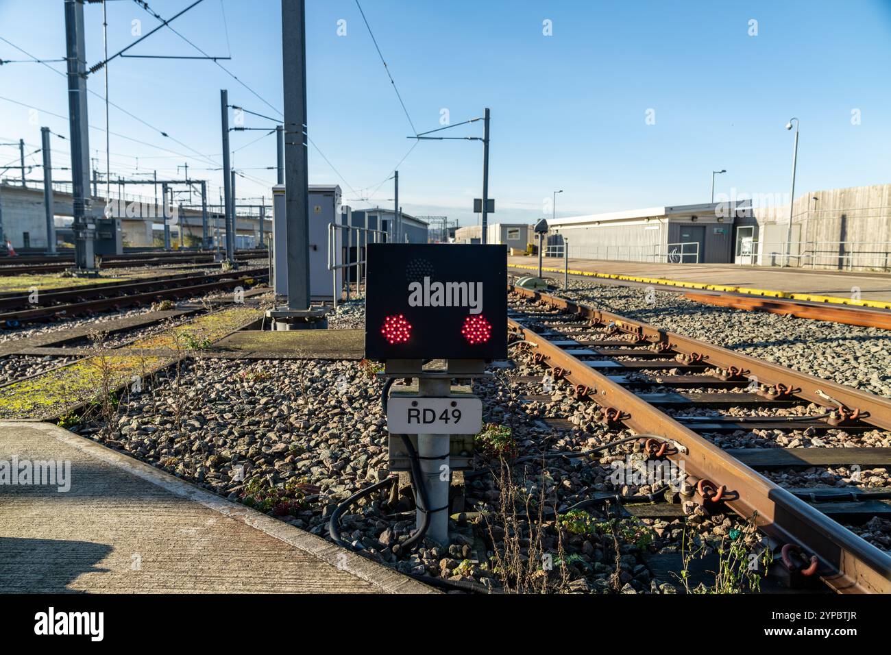 Rote LED-Warnleuchte blinkt an einem Bahnbetriebswerk und weist auf potenzielle Gefahren und die Notwendigkeit der Vorsicht hin Stockfoto