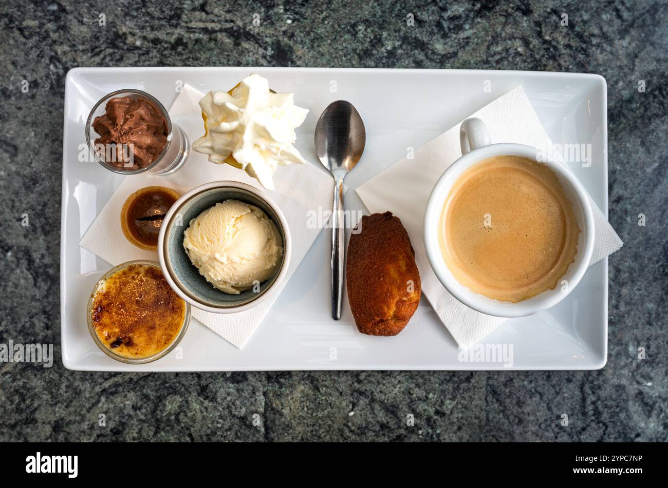 Kaffee serviert mit süßen Dessets wie Kuchen, Vanilleeislöffel und Pudding in Leuven, Belgien Stockfoto