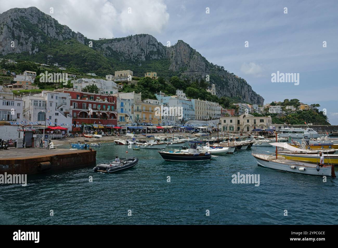 Der Hafen von Capri, Italien, mit Booten und farbenfrohen Gebäuden entlang der Küste, wird tagsüber gezeigt. Stockfoto