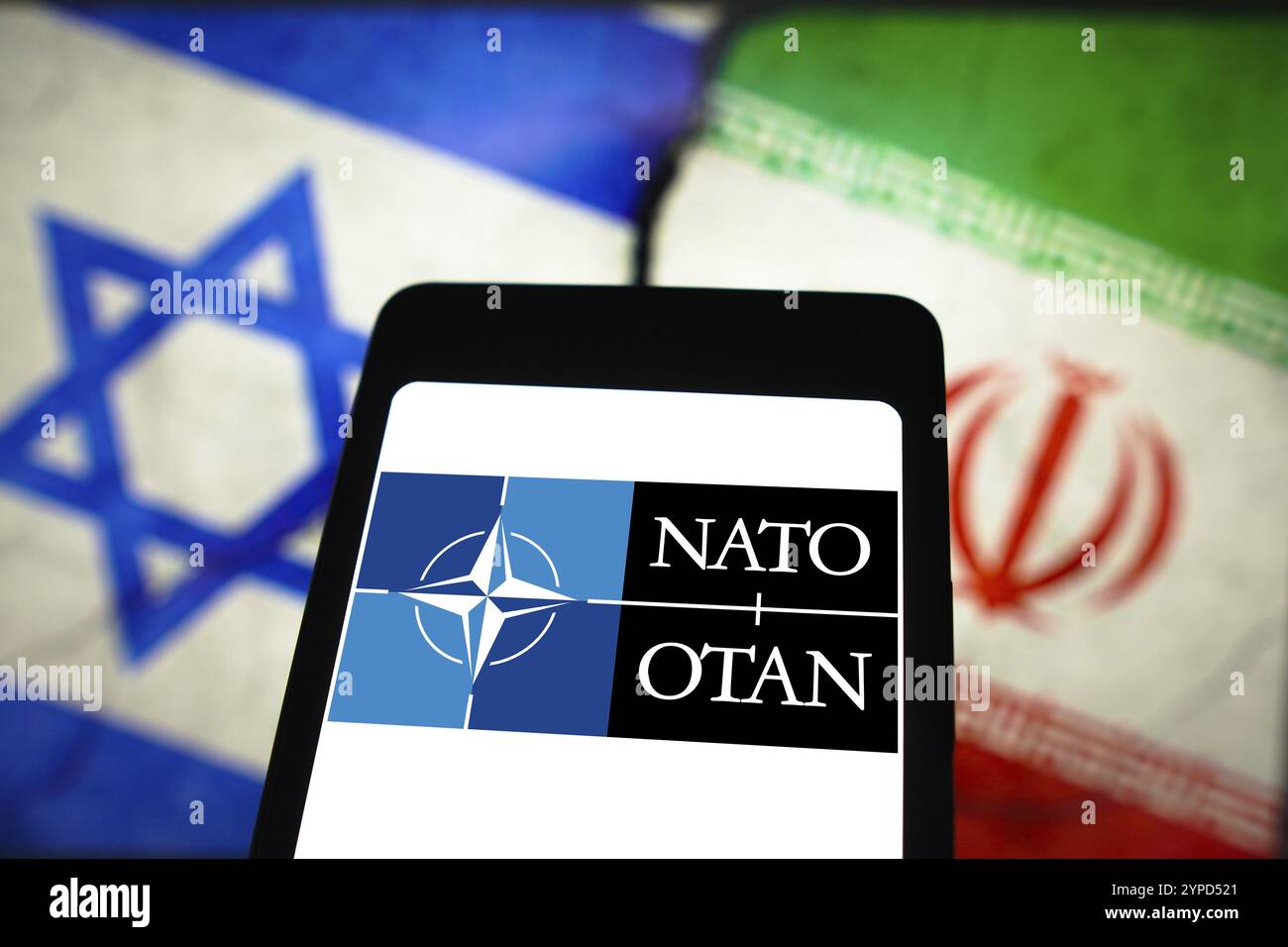 April 2024, Brasilien. In dieser Fotoabbildung wird das Logo der Nordatlantischen Vertragsorganisation (NATO) auf einem Smartphone-Bildschirm und Flaggen o angezeigt Stockfoto