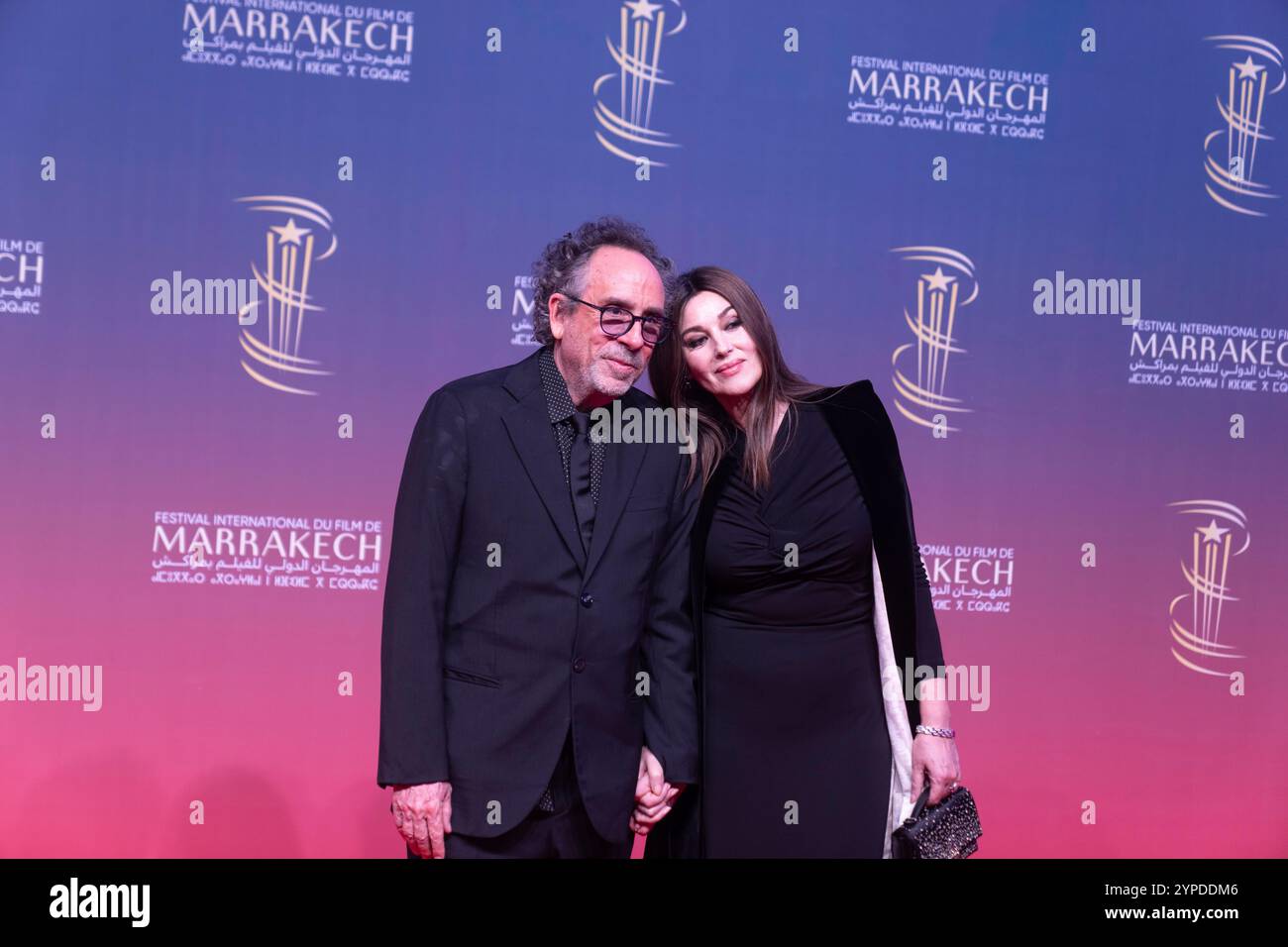 Italian actress Monica Belluci and American director Tim Burton pose during the opening ceremony of the 21st Marrakech International Film Festival, in Marrakech, Morocco, Friday, Nov. 29, 2024. (AP Photo/Mosa'ab Elshamy) Stockfoto