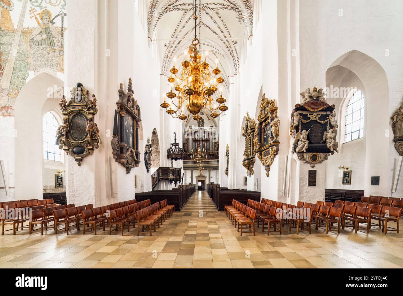 Hauptschiff der Kathedrale von Aarhus mit großem Kronleuchter, dekorativen Wänden, Holzbänken und Orgel am anderen Ende Dänemark Stockfoto