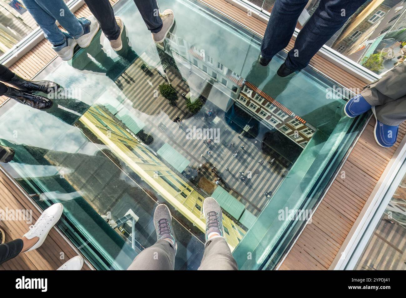 Aussichtsplattform mit Glasboden in Aarhus, Dänemark, mit stehenden Personen und freiem Blick auf die Straße und die darunter liegenden Gebäude, was eine schwindelerregende und aufregende atmosphäre schafft Stockfoto