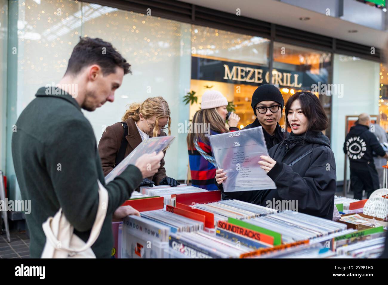 London, Großbritannien, 22. November 2024. Spitalfields Antiquitätenmarkt. Ein junger Mann und eine junge Frau wählen Schallplatten von einem der Tische mit Musik aus. Stockfoto