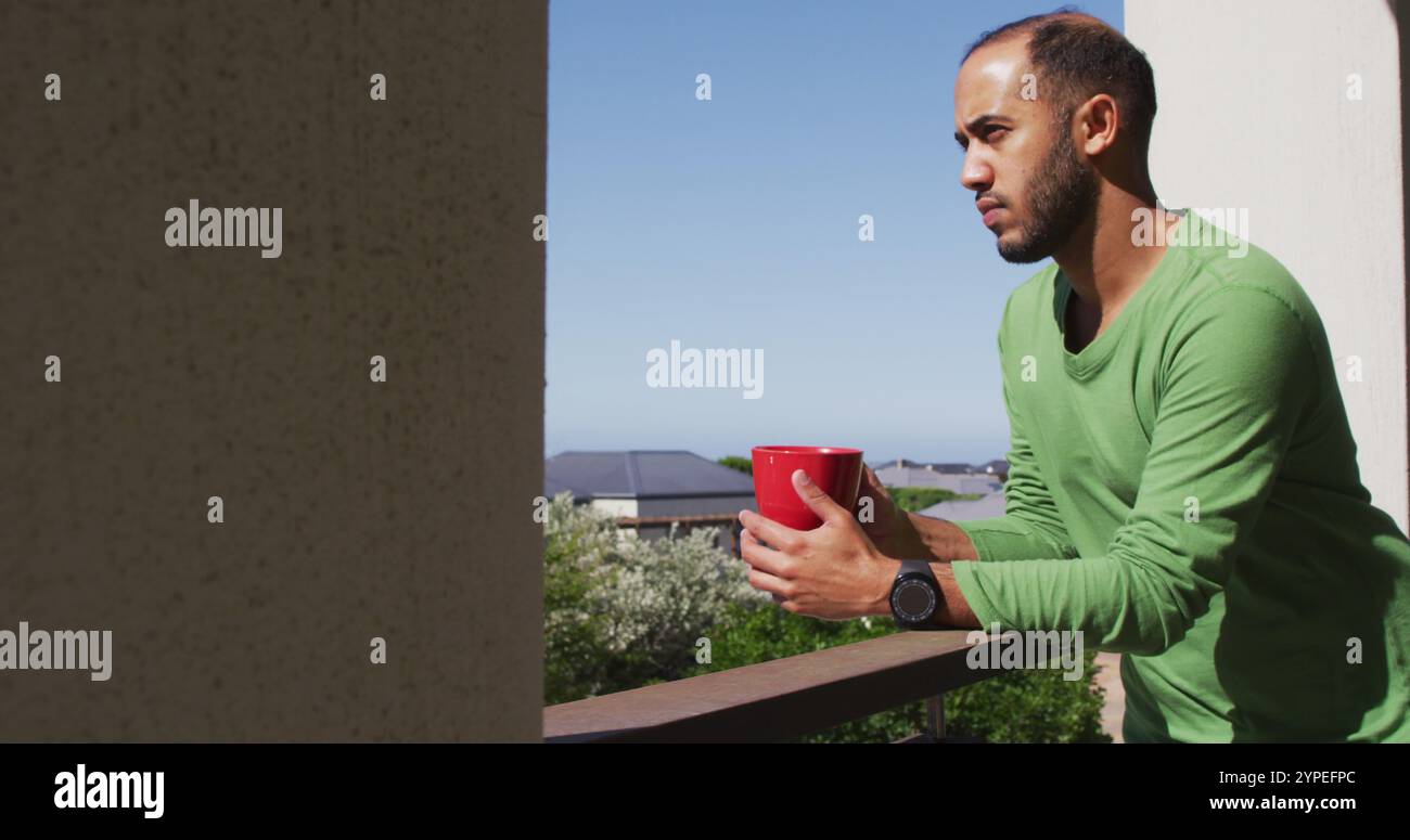 Birassischer Mann trinkt Kaffee auf dem Balkon in der Sonne Stockfoto