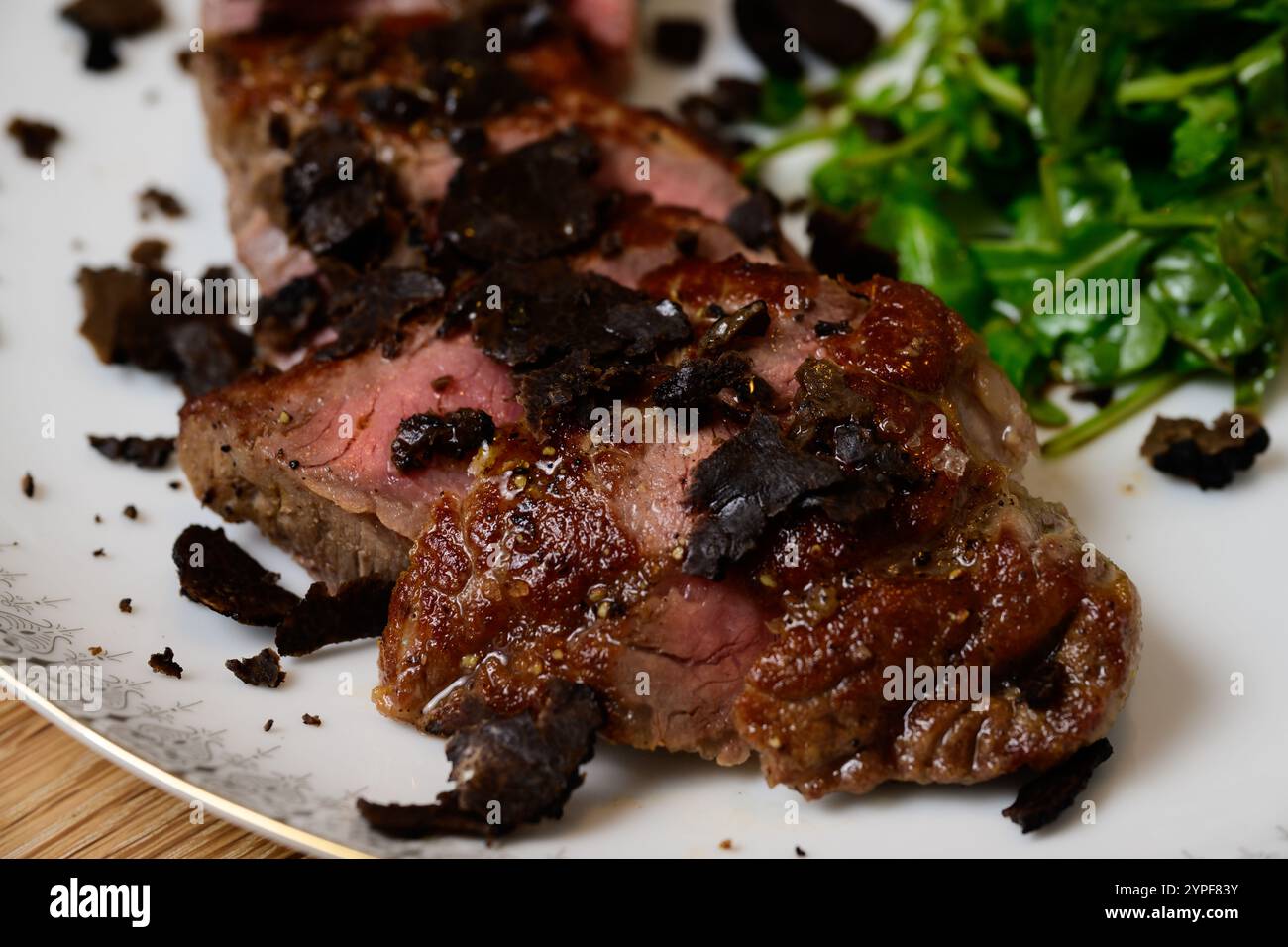 Tagliata di Manzo al Tartufo Rindersteak mit Trüffeln serviert mit grünem Rocket- oder Arugula-Salat Stockfoto