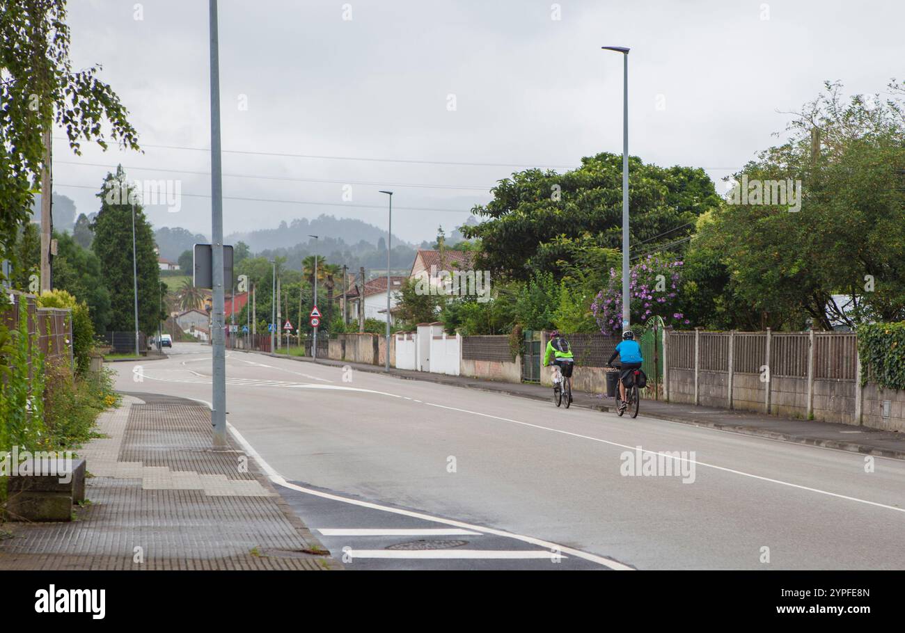 MTB-Radfahrer auf der Route durch eine ländliche Stadt. Bedeckter Himmel Stockfoto
