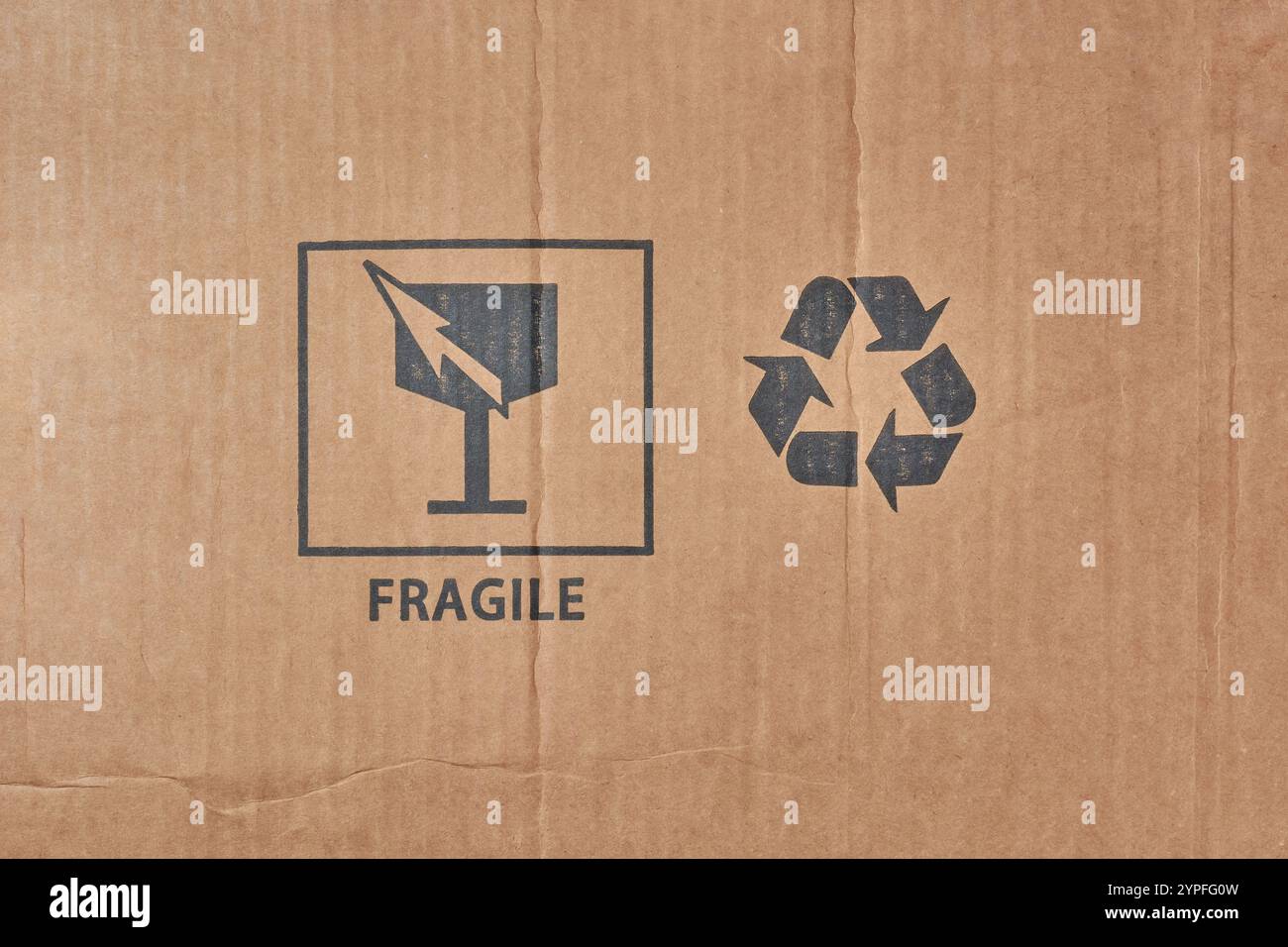 Zwei auf Karton aufgedruckte Versandsymbole, zerbrechliche Symbole und Recycling-Symbole mit wichtigen Anweisungen für den sicheren Transport und die sichere Lagerung Stockfoto