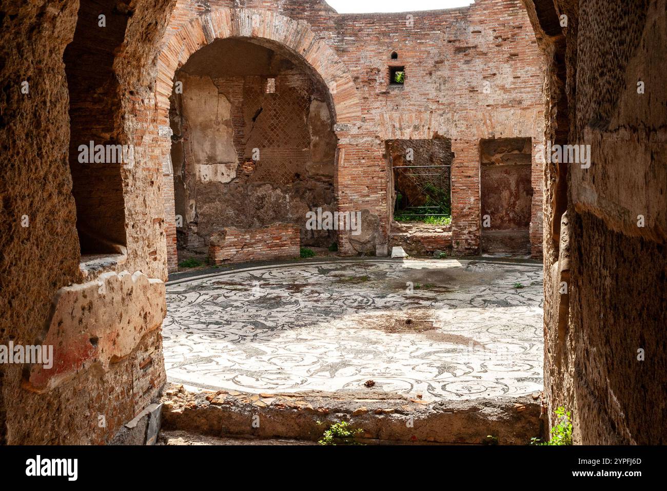 Ein kreisförmiger schwarz-weißer Mosaikboden in den Thermen der Sieben Weisen in Ostia Antica, der vegetative Elemente und Jagdszenen darstellt. Die MOS Stockfoto