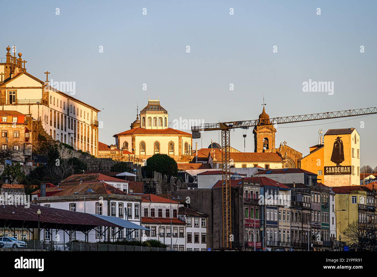 Porto, Portugal - 28. Juli 2024: Gebäude in der Abenddämmerung mit einem Gebäude mit dem Logo des Weinguts Sandeman. Stockfoto