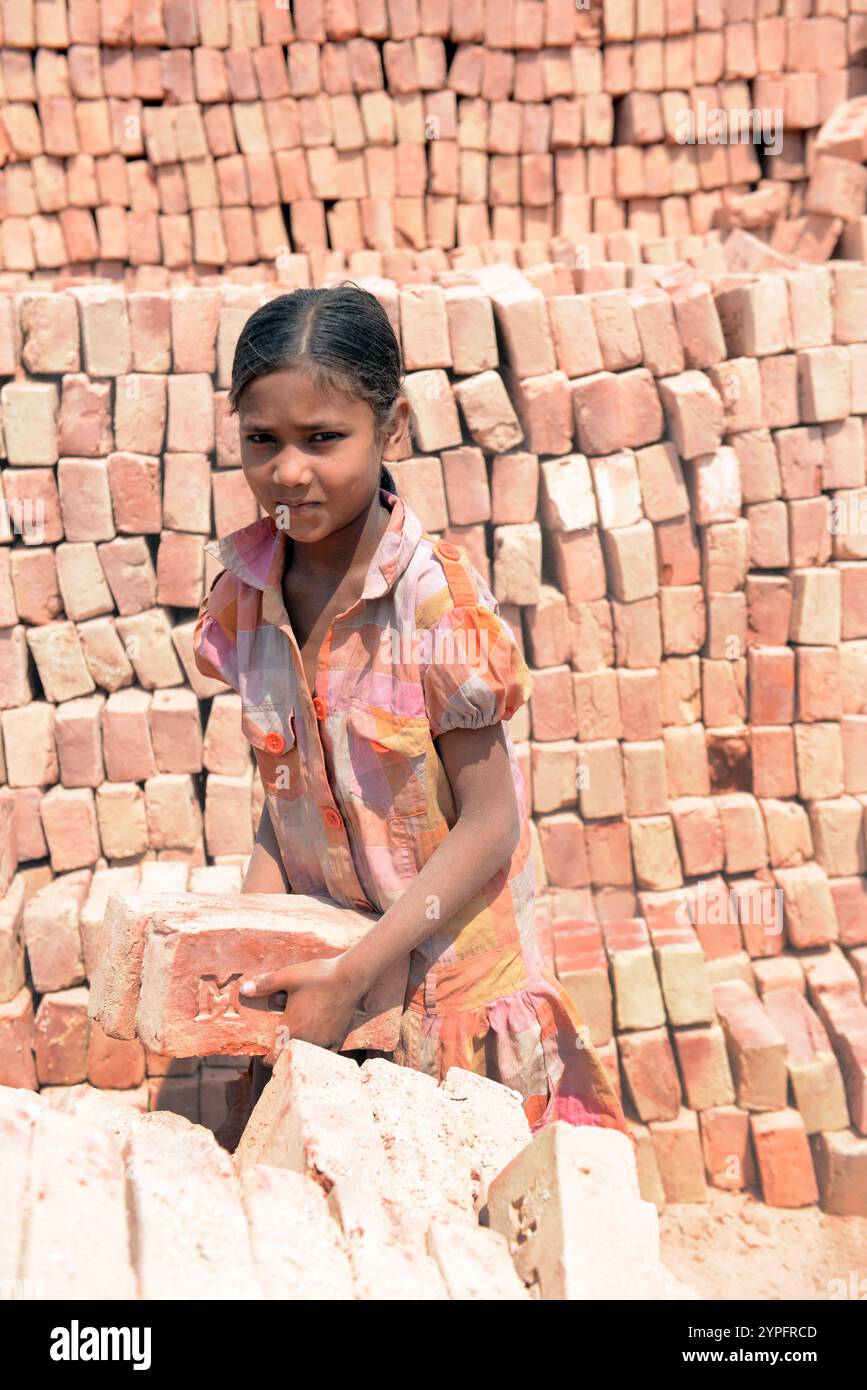Ein Mädchen, das in einer Ziegelfabrik am Stadtrand von Dhaka, Bangladesch, arbeitet. Stockfoto