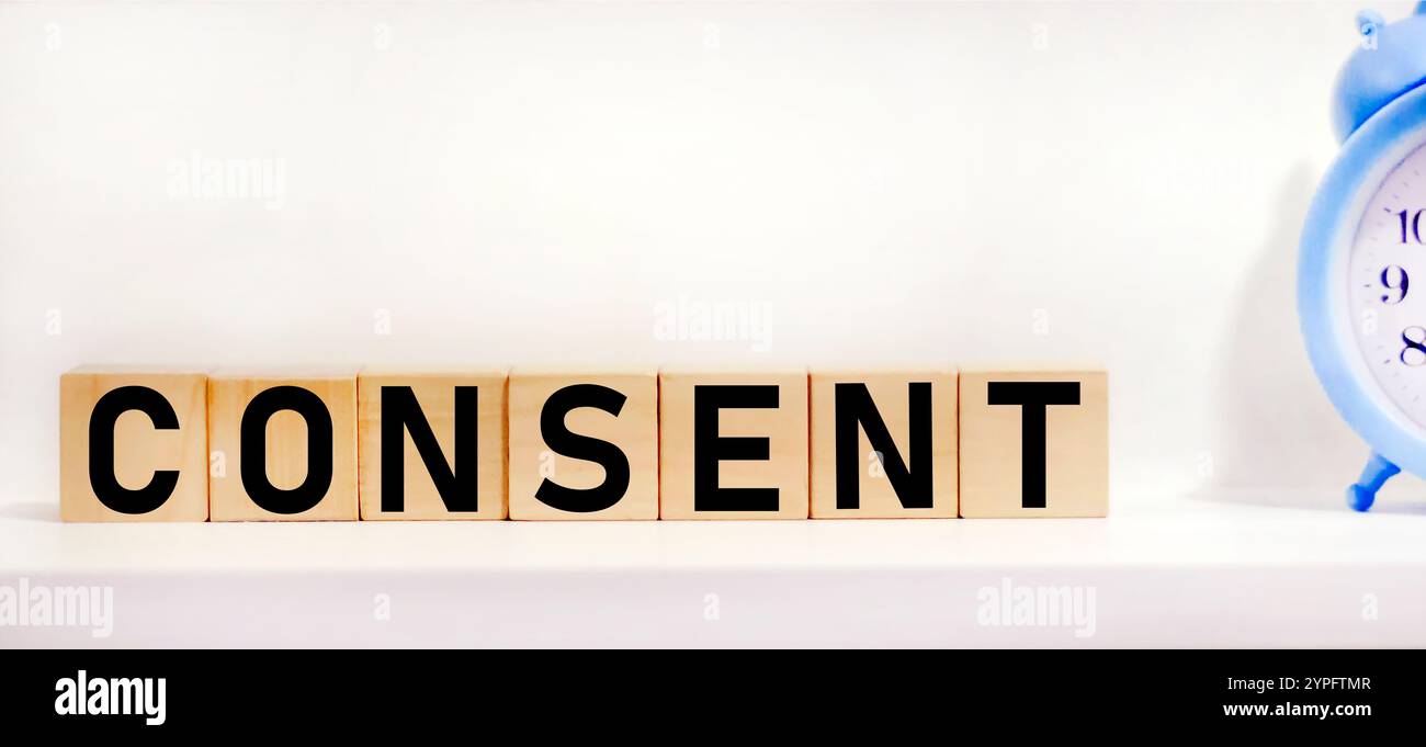 Die auf weißem Hintergrund hervorgehobene Inschrift CONSENT auf Holzwürfeln spiegelt das Konzept von Wirtschaft und Finanzen wider. Stockfoto