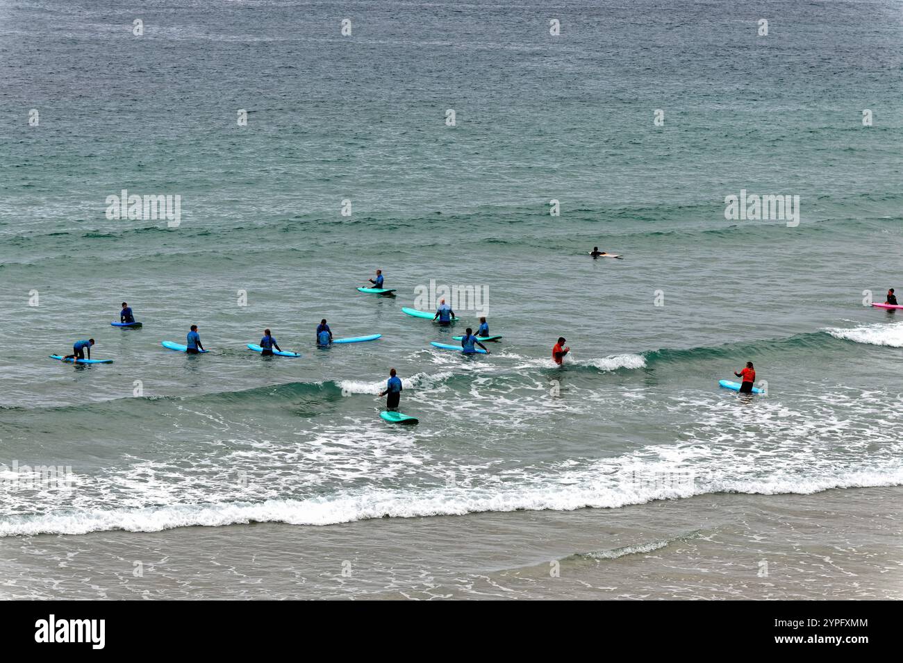Eine große Gruppe von Menschen lernt Surfen am Strand von Sennen Cove Cornwall England UK Stockfoto