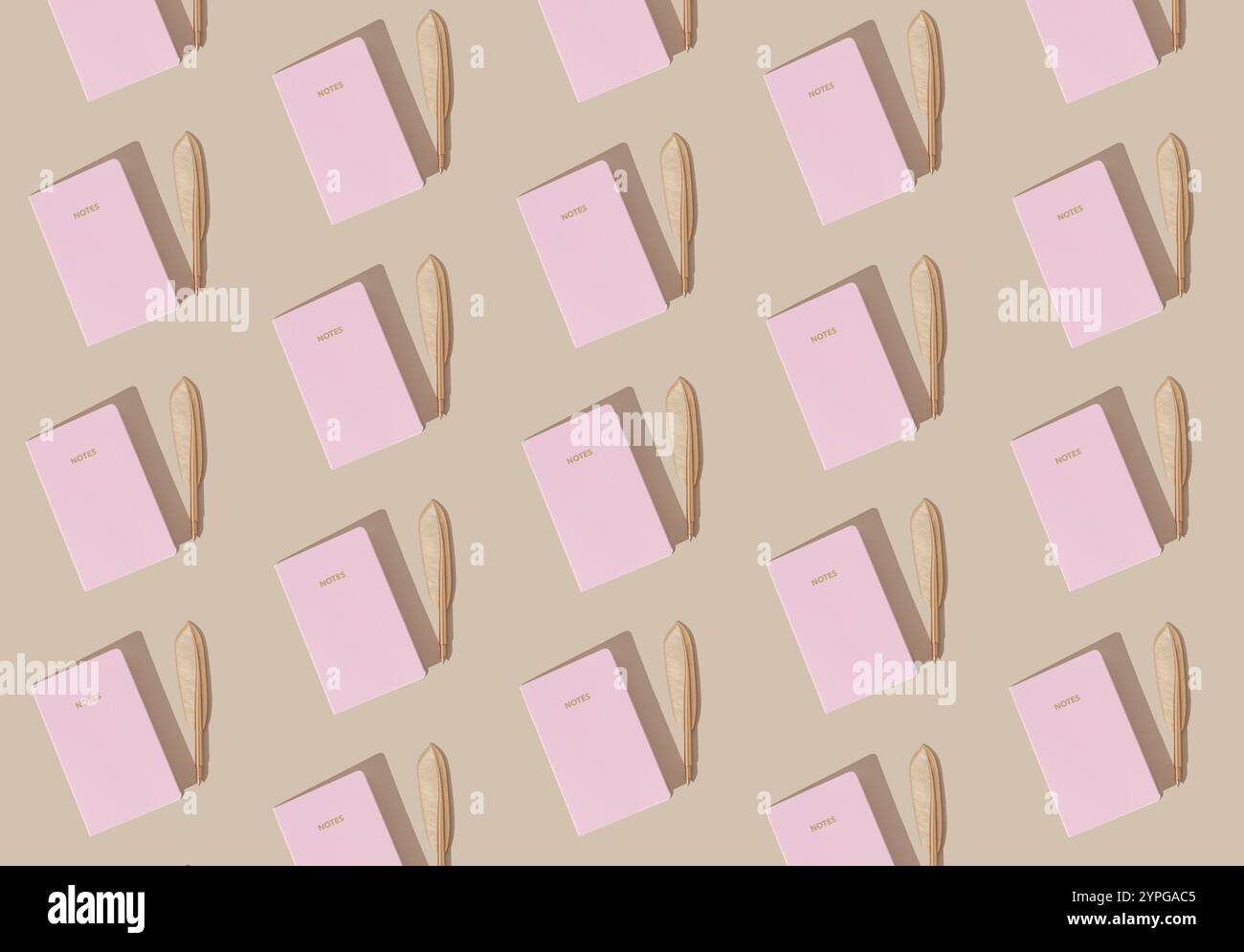 Kreatives trendiges Muster mit pastellrosa Noten und goldenem Federstift auf pastellfarbenen cremefarbenen Hintergrund. Minimales Konzept. Flache Lagen. Stockfoto
