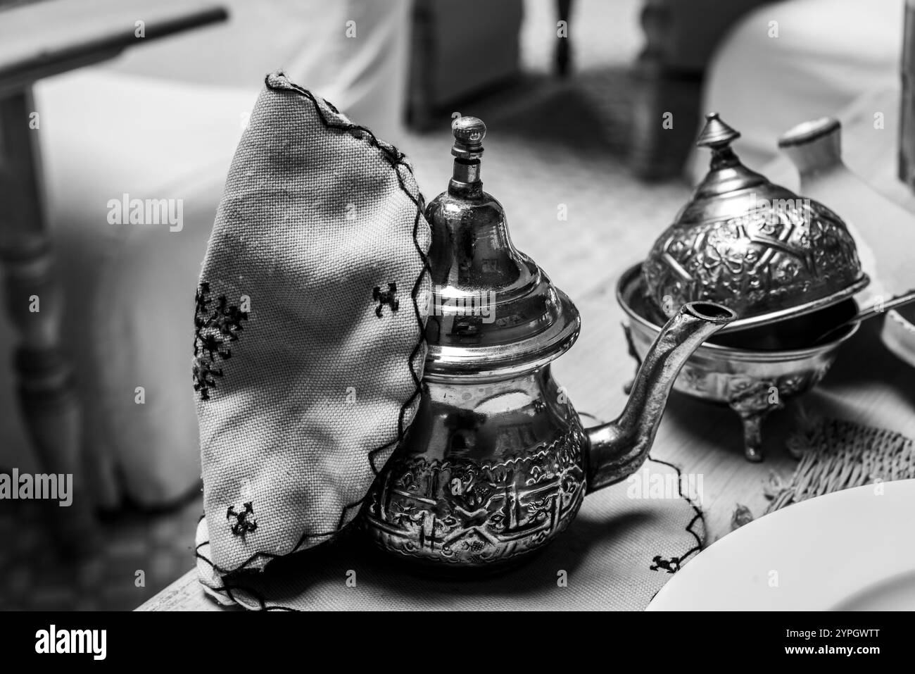 Nahaufnahme einer klassischen marokkanischen Metall-Teekanne mit handgesticktem orangenem Topfhalter in Marrakesch Marokko Stockfoto