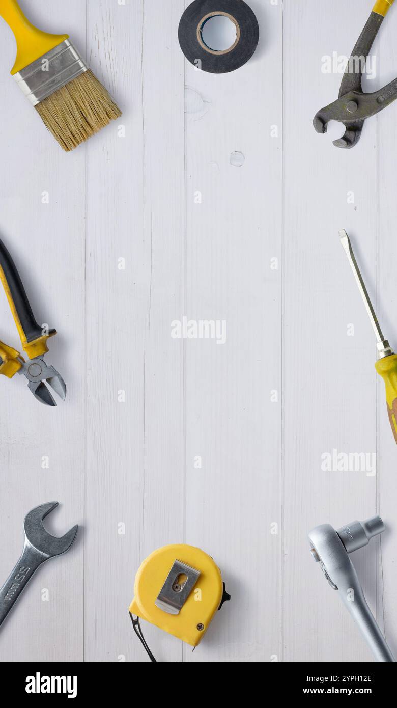 Flache Platzierung einer Werkbank mit Werkzeugen wie Zange, Bandmaß, Schraubendreher und Pinsel, mit einem zentralen Leerraum für Werbezwecke Stockfoto