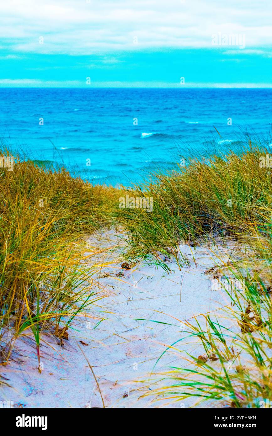 Michigan State Highway, M-116, schlängelt sich an einem windigen Tag durch den Ludington State Park mit Blick auf Lake Michigan und Sanddünen in der Nähe von Ludington, Michigan, Stockfoto