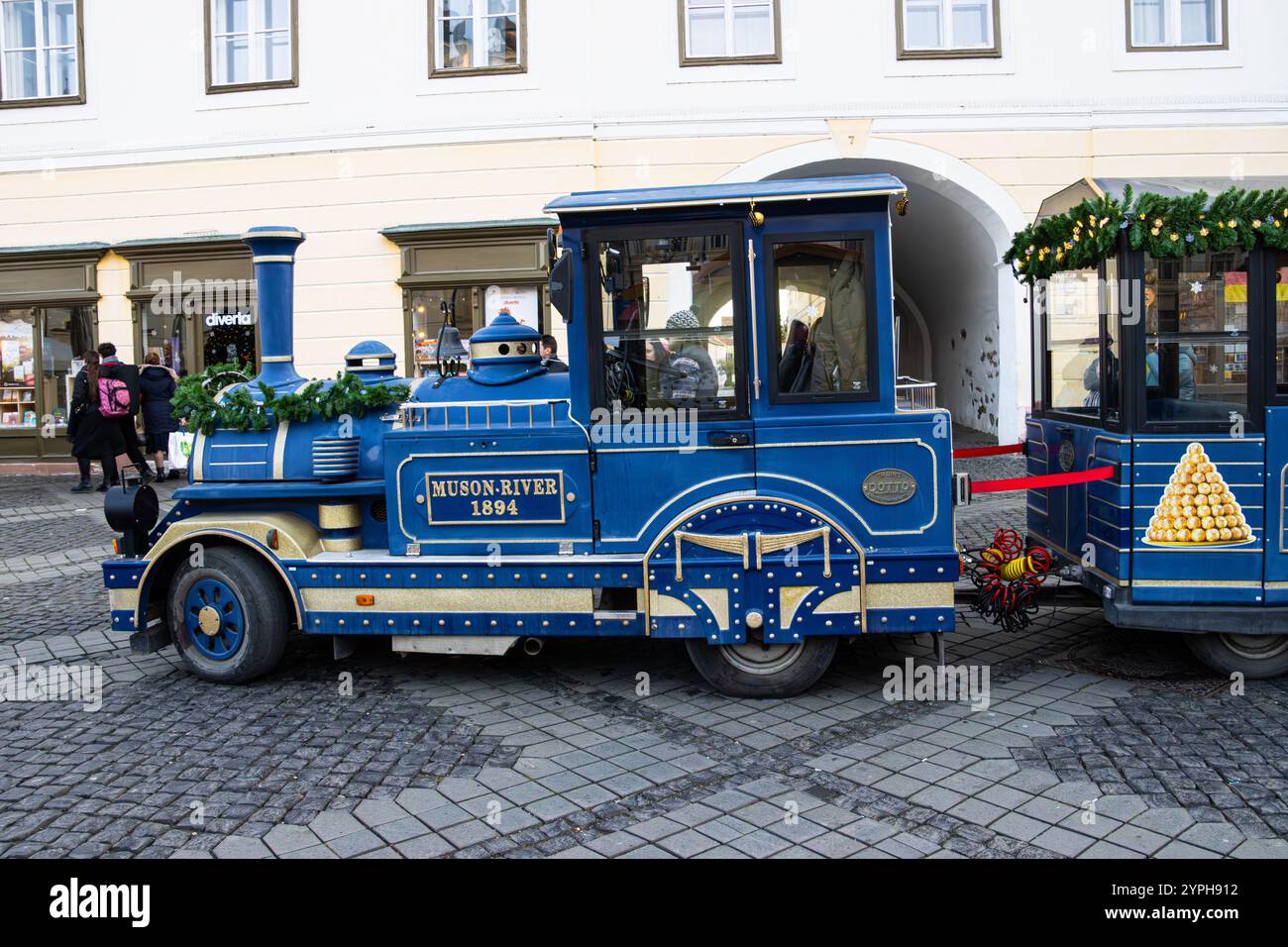 Minizug für Touristen. Blaue Lokomotive eines Sightseeing-Zuges auf dem Weihnachtsmarkt in Sibiu, Rumänien Stockfoto