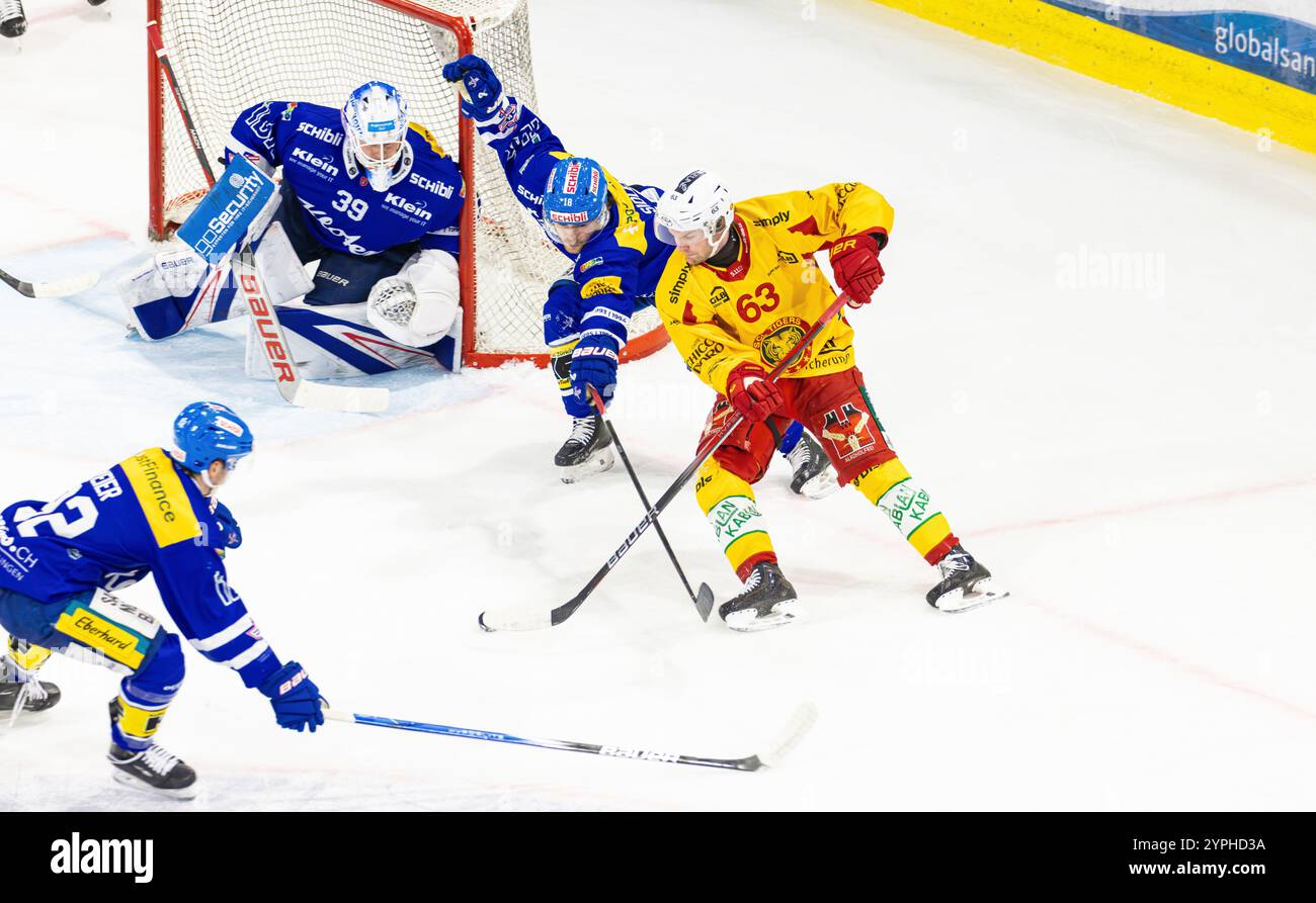 Kloten, Schweiz, 30. November 2024: #63 Dario Rohrbach (Langnau) zieht mit der Rückhand vor dem Tor von #39 Sandro Zurkirchen (Kloten) den Puck. Verteidiger Nr. 18 Dario Sidler (Kloten) will das verhindern. (Foto: Andreas Haas/dieBildmanufaktur) Credit: DieBildmanufaktur/Alamy Live News Stockfoto